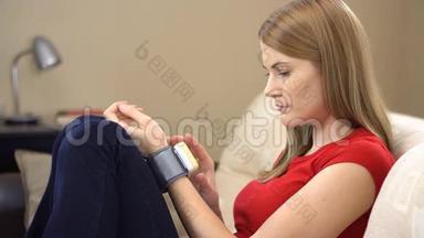一位年轻漂亮的女士坐在沙发上，用腕表检查她的血压